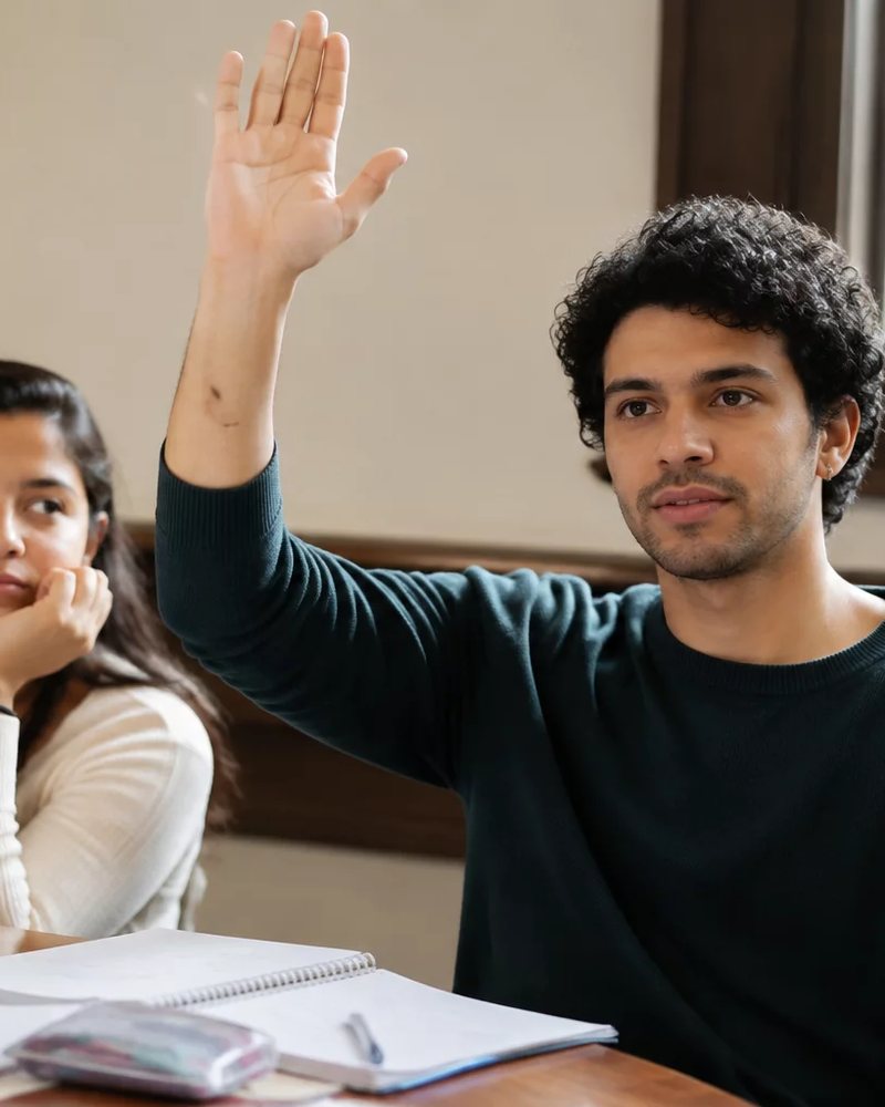Dupla preparando uma rodada de debate, com cadernos e canetas espalhados na mesa