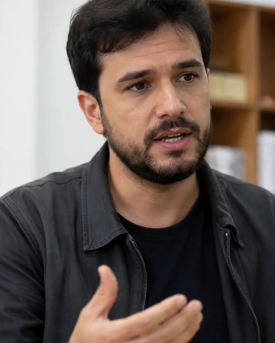 Participante em pé no meio da roda, segurando a folha de anotações enquanto fala